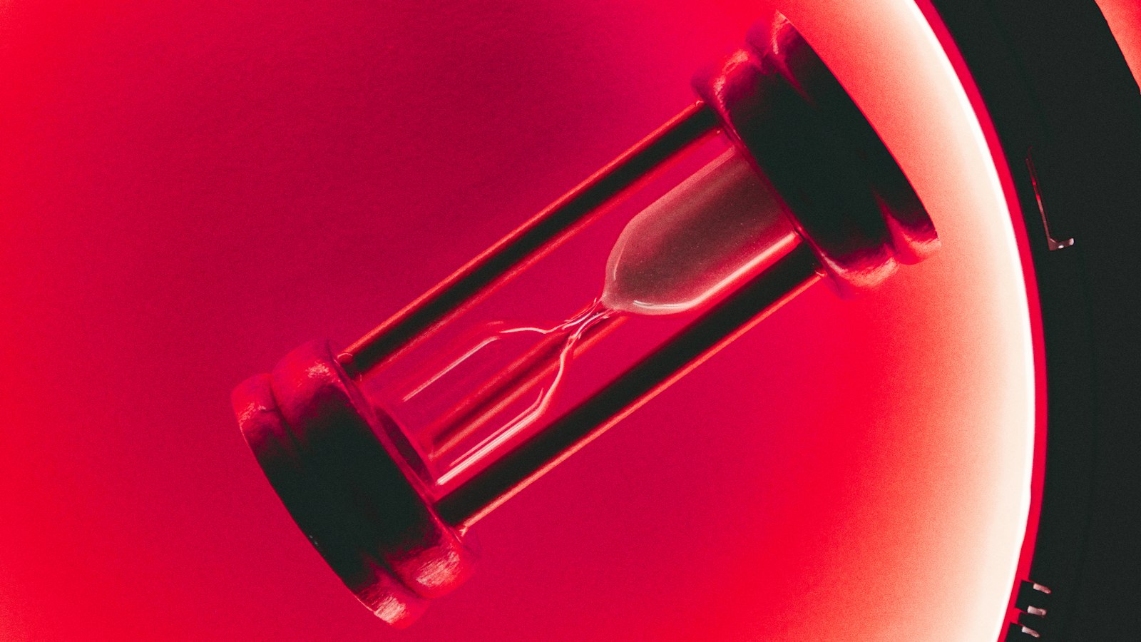 An hourglass glowing in hot pink light